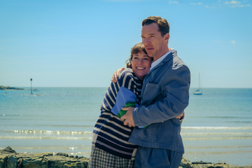 couple embracing on a beach with a calm sea in the background