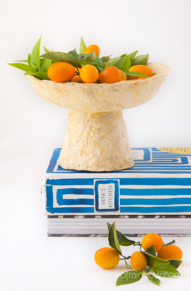 bowl of kumquats on stacked cookbooks