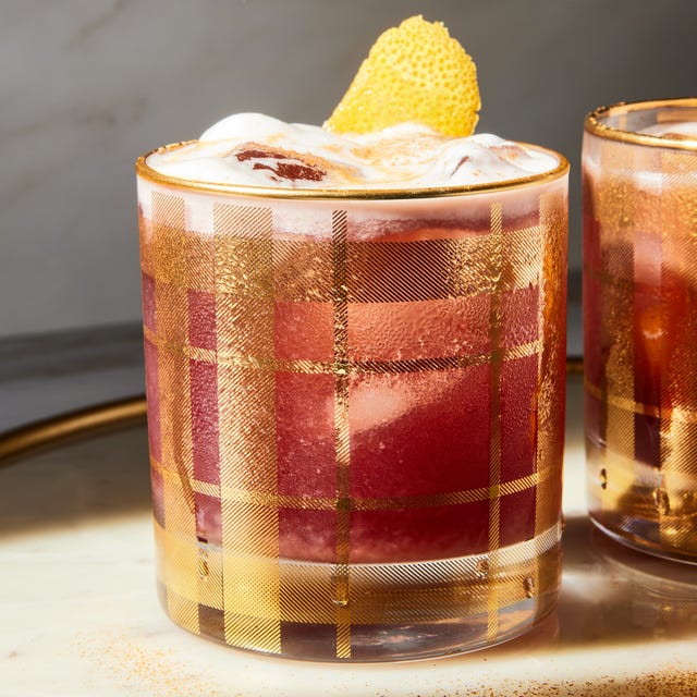 Scrooge Sour a red tinted sour garnished with an orange twist