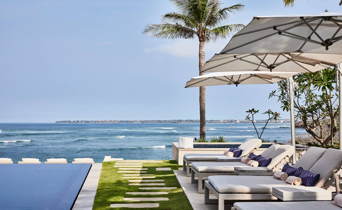 lounge area beside an infinity pool overlooking the ocean