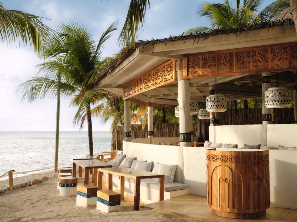 a building with tables and chairs by the water