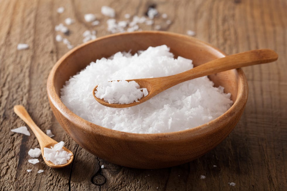 sea salt and spoons in wooden bowl