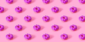 seamless pattern of glazed donuts on pink background