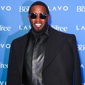 sean diddy combs smiles at the camera, he wears all black including black sunglasses