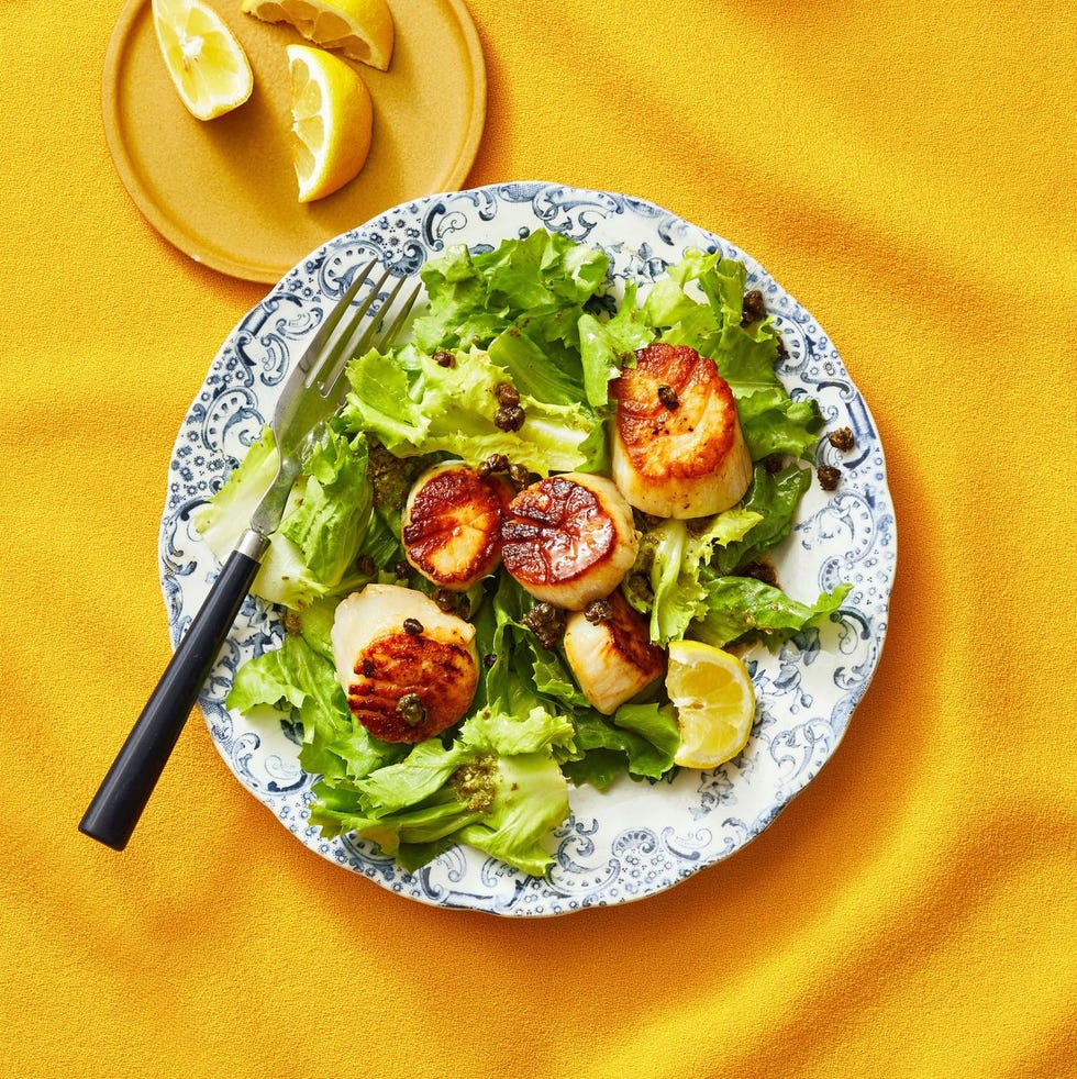 seared scallops with escarole salad and pesto vinaigrette on a plate