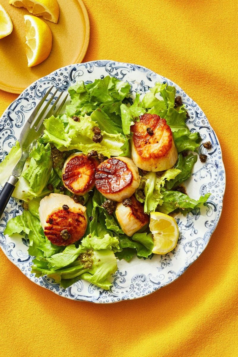 a plate of food with seared scallops and escarole greens