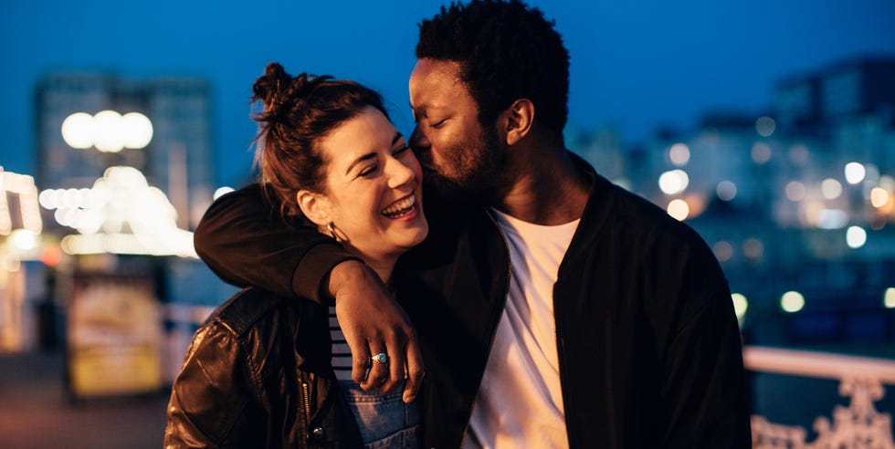 Parejas junto al mar una pareja que se ríe sonriendo afuera por la noche