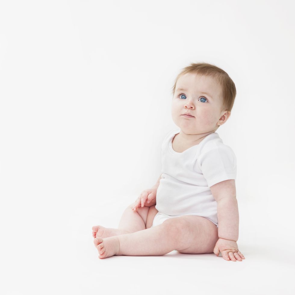 seated baby girl looking upwards