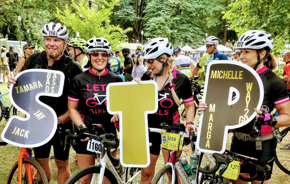 riders celebrate the seattle to portland ride in 2022 with signs