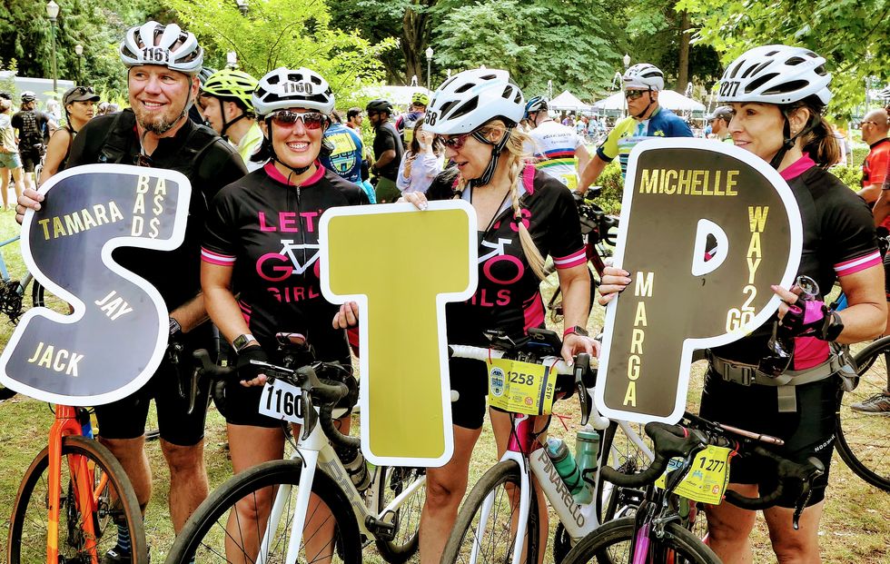 riders celebrate the seattle to portland ride in 2022 with signs