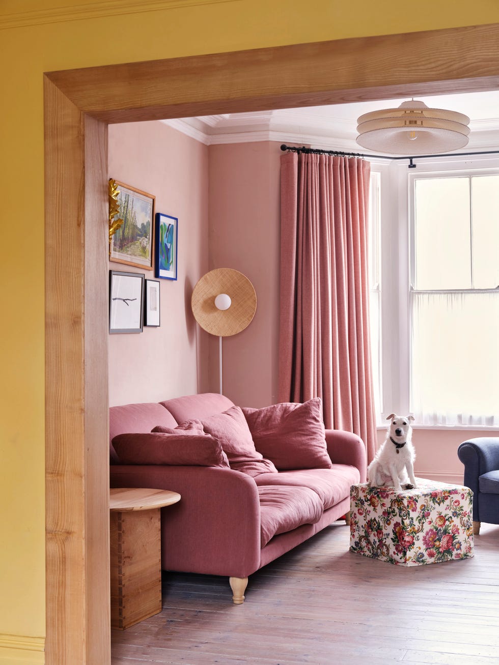 a pink living room with pink curtains and pink sofa
