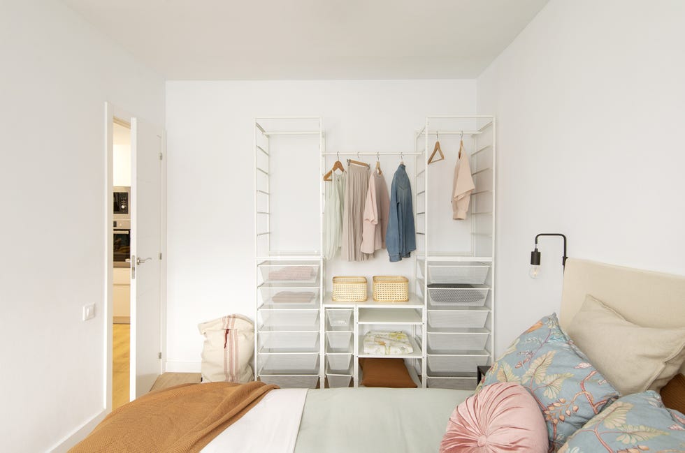 dormitorio de diseño nórdico con vestidor abierto de color blanco