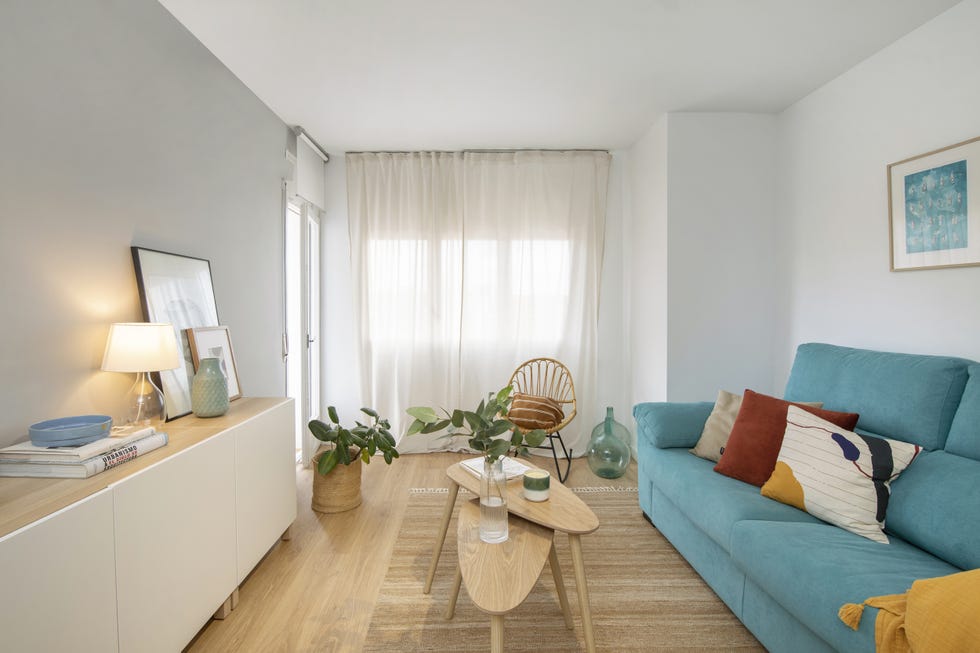 salón de estilo nórdico con sofá tapizado en color azul