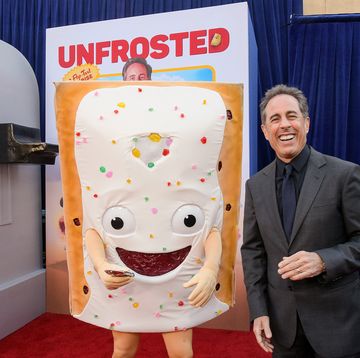 jerry seinfeld smiling as he stands next to a pop tart mascot at the premiere of his film unfrosted