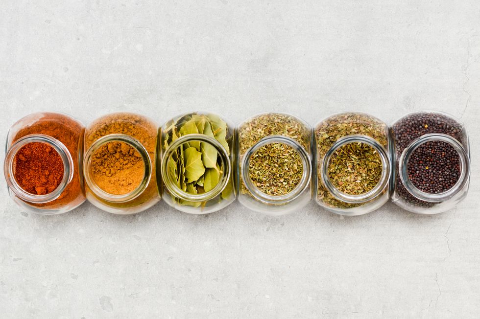 a selection of herbs and spices for adding flavour to food when cooking on a kitchen worktop at high angle