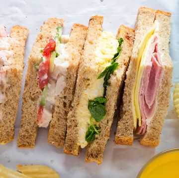 selection of sandwiches on malted brown bread. prawns with mayonnaise. roast chicken breast, vine tomatoes, cucumber, mayonnaise. egg mayonnaise and watercress. ham and cheddar cheese on mayo.
