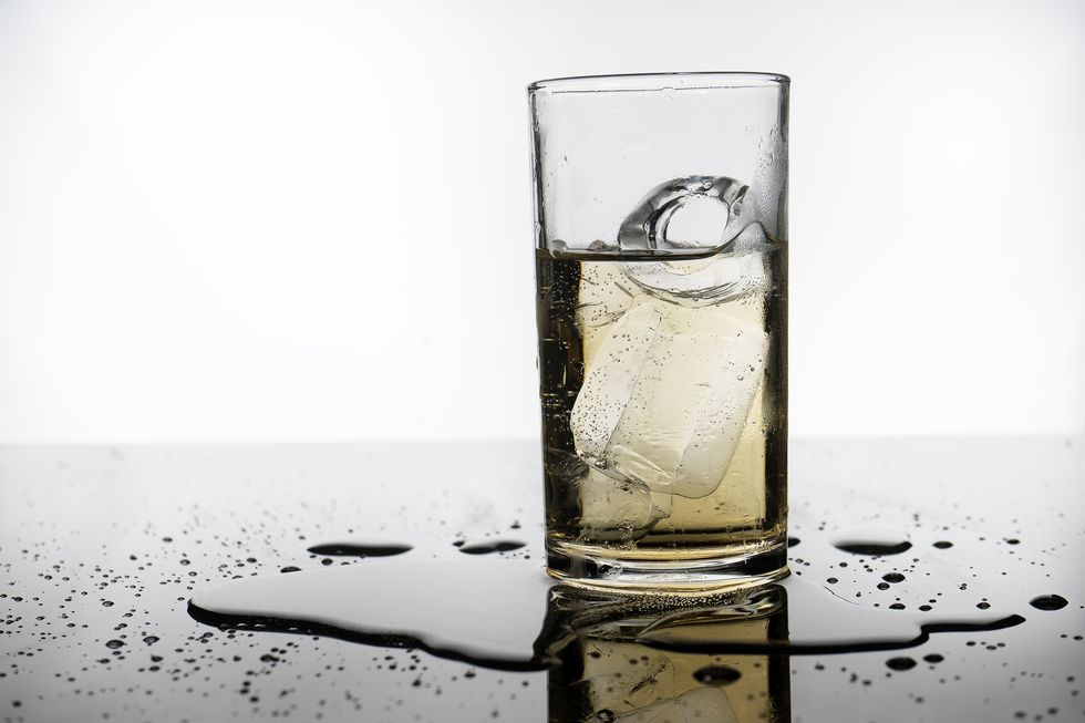 selective focus drink alcohol and water glass with whisky and sparking water and ice cube
