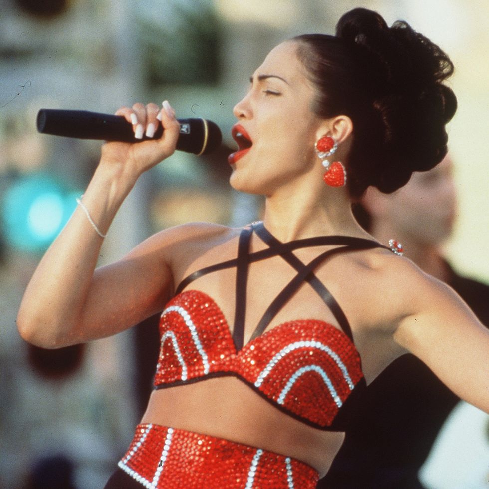 jlo as selena singing into a microphone