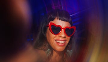 a party scene featuring a person in bright sunglasses and discothemed attire