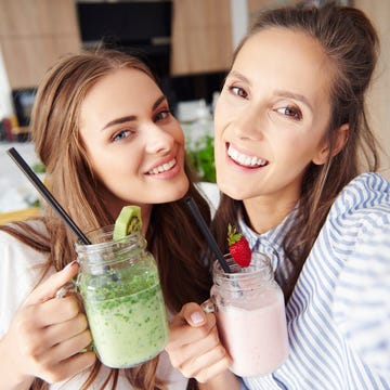 selfie of happy friends holding smoothies