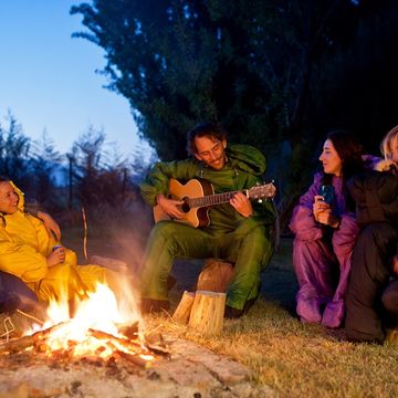 people wearing  selk’bag wearable sleeping bags around a campfire