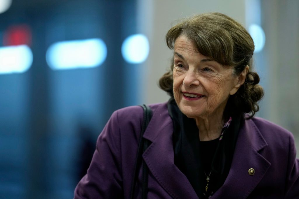dianne feinstein wearing a purple coat and smiling