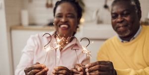 new years eve instagram captions  senior african american couple lighting sprinklers for the 2022 new year's eve
