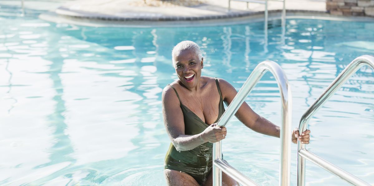 bathing suits for women over 50, senior african american woman on swimming pool ladder  swimsuits for women over 50