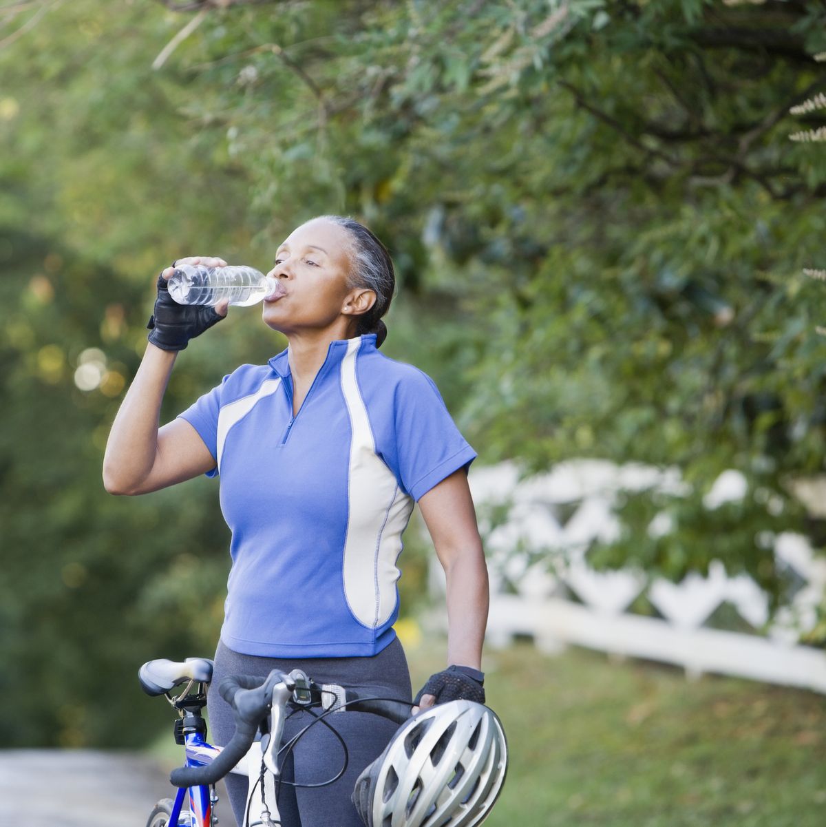 senior african female cyclist drinking water
