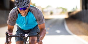 Senior Black Man Racing on a Road Bike