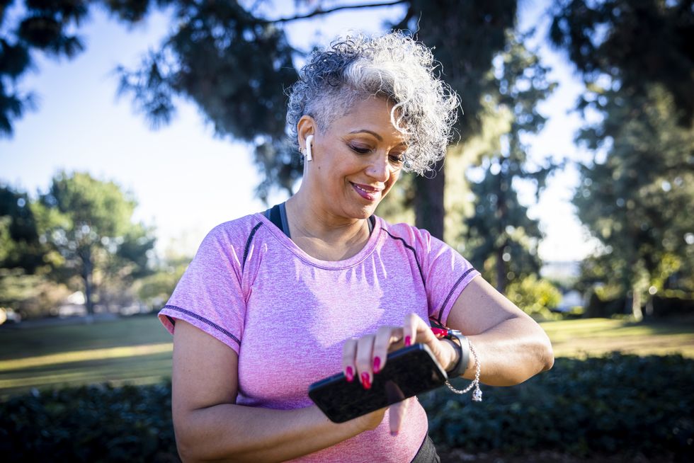 senior black woman running with a fitness tracker