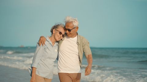 dating sites over 50 senior couple embrace on the beach at not sunny day