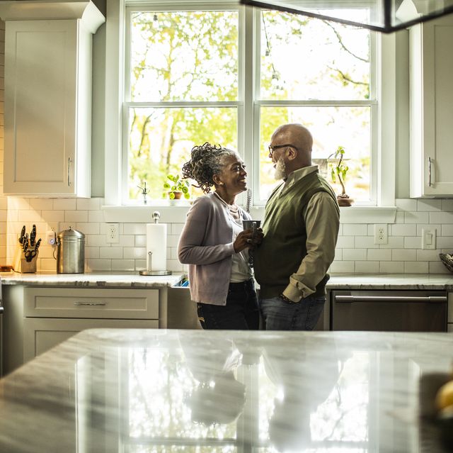 senior couple embracing in kitchen of suburban home