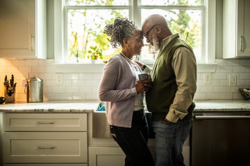 senior couple embracing in kitchen of suburban home