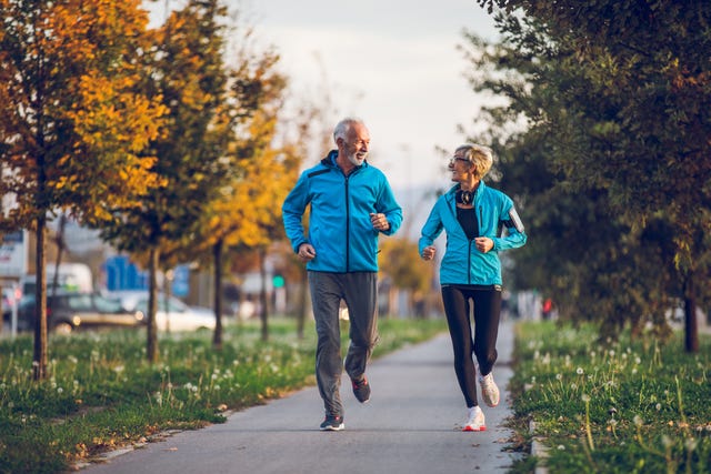 Senior couple in sports clothing jogging together