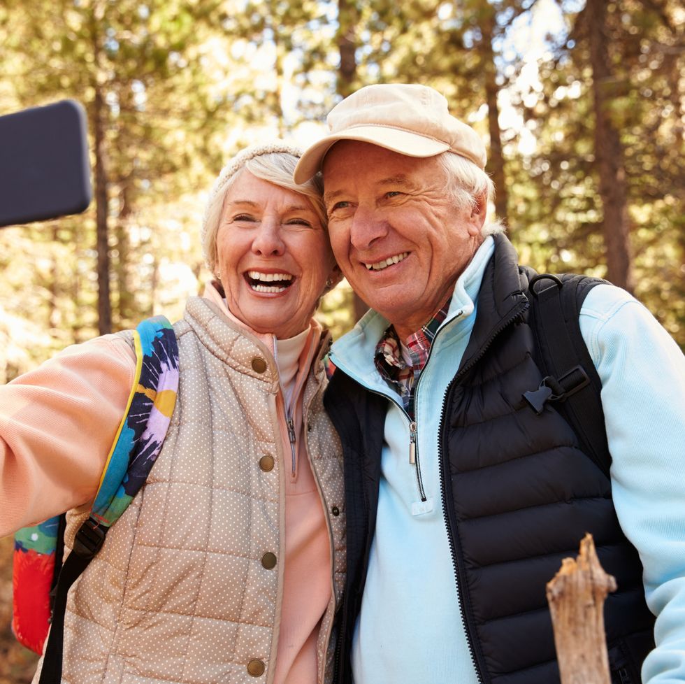 Senior couple on hike in a forest taking a selfie
