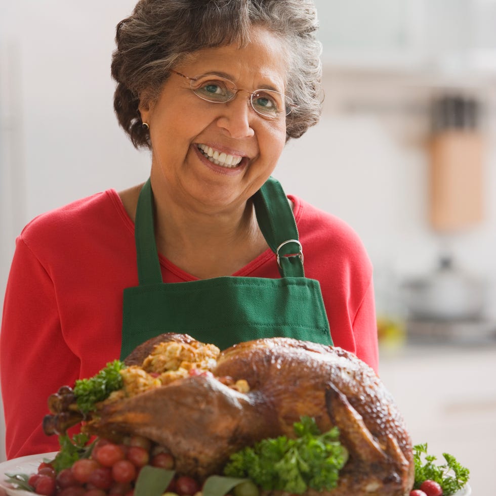Senior Hispanic woman holding roasted turkey senior hispanic woman holding roasted turkey