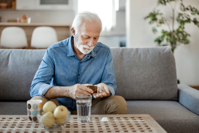 senior male taking pills