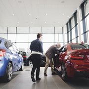 senior man and woman examining car at showroom