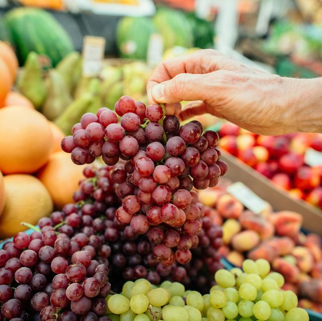senior man choosing grapes at a farmer's market