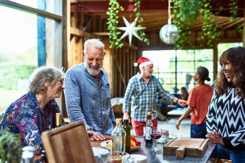 senior man smiling and laughing with friends at christmas gathering