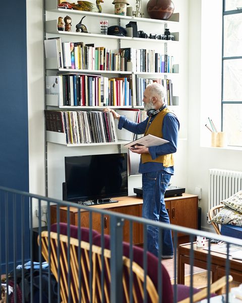 Senior man sorting through his record collection in living room