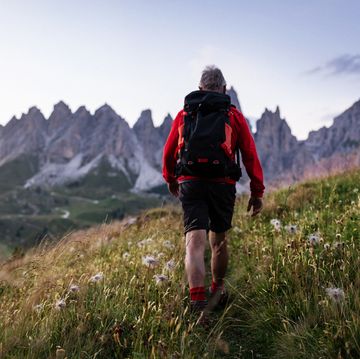 senior man trail hiking on the dolomites, italy, during summer vacations