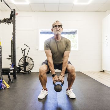 senior man using kettle ball at physical therapy