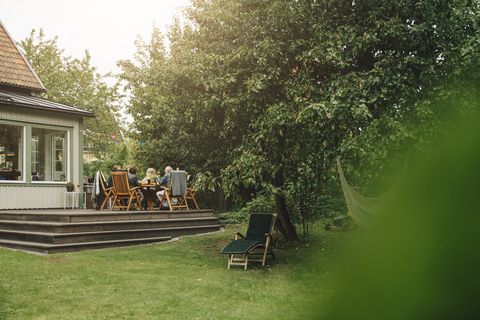 senior men and women enjoying dinner while sitting dining table during garden party