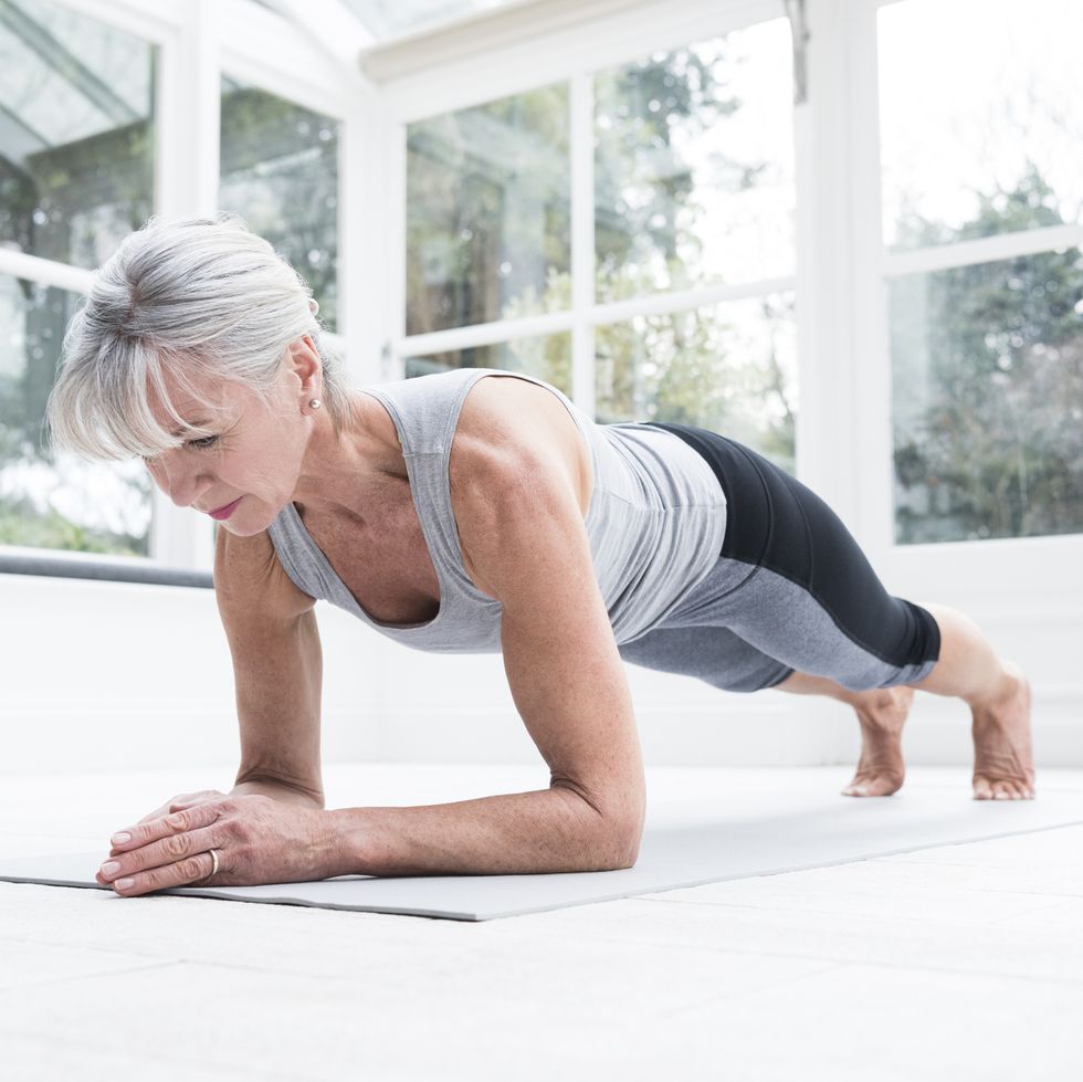senior woman in plank position in conservatory