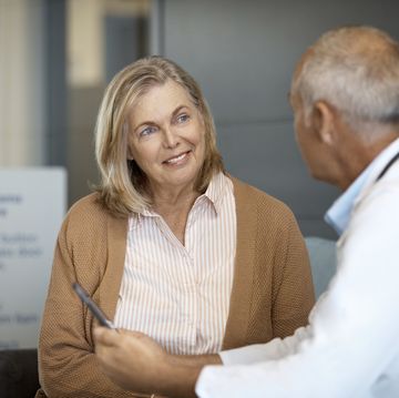 senior woman listening to male doctor in hospital