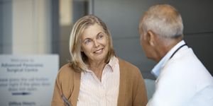 senior woman listening to male doctor in hospital