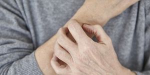 Senior woman scratching arm, close-up