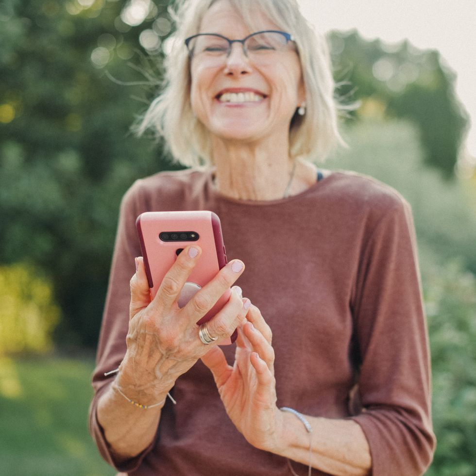 signs of midlife crisis turning down opportunities senior woman smiling while using her smartphone